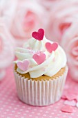 Cupcake decorated with frosting and pink sugar hearts