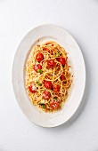 Spaghetti with tomato sauce, roasted tomatoes and parmesan on white background