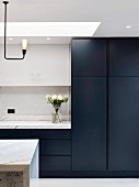 Purist kitchen with black fronts and marble worksurfaces