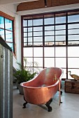 Freistehende, nostalgische Kupferbadewanne vor Verglasung mit Fenstersprossen