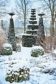 Winter garden with snow-covered topiary trees