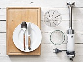 Kitvhen utensils: a hand blender, cutlery, measuring jug and glass