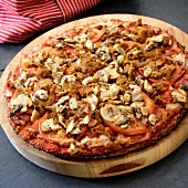 A pizza with mushrooms, sausage and tomatoes