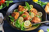 Chicken with lemon and basil in a pan