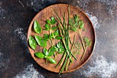 Assorted fresh herbs on a wooden plate
