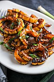 Roasted pumpkin wedges with spring onions and sesame seeds