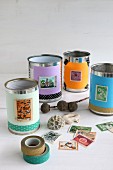 Tin cans covered with paper, postage stamps and washi tape