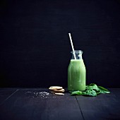 Vegan green smoothie with leaf spinach in a glass bottle