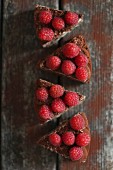 Four slices of mini chocolate cake with raspberries (seen from above)