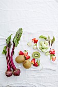 Beetroot, kiwi, strawberries, and brussels sprouts on a white background