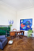Retro Schreibtisch und moderne Gemälde in Wohnbereich mit Eichenparkett