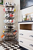 Collection of colourful mugs on old bottle-drying rack