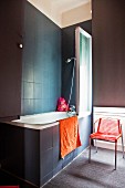 Dark tiles and walls in bathroom with red accents