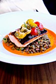 Pan-fried fillet of salmon on a bed of lentils with dried tomato jus and cherry tomato salsa