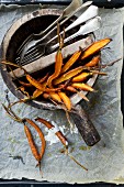 Baked carrots in a wooden bowl with cutlery