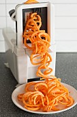 Sweet potato spirals being cut with a spiraliser