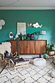 Ornaments on retro sideboard against green wall in comfortable living area
