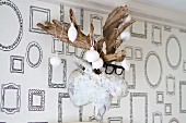 Christmas-tree baubles dipped in plaster and hung from fake moose head on wall