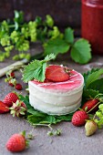 A sponge cake covered with white chocolate and strawberries