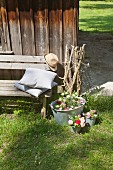 Zinc tub and buckets decorated with flowers outside wooden cabin