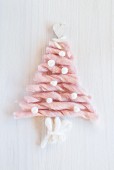 Christmas tree formed from sections of pink wool on white surface