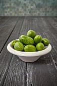 Olives (from Arbosana, Chile) in a bowl on a wooden surface