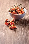 Fresh sea buckthorn in a bowl and next to it on a wooden surface