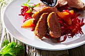 Entenbrust mit Orangenfilets auf Rotkraut (Nahaufnahme)