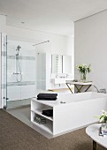 White bathtub and shower area in elegant modern bathroom