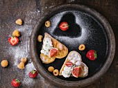 Wafers as heart shape with yellow raspberries, strawberries, sliced figs, ricotta cheese and sugar powder