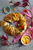 A bread ring with pumpkin seeds and nasturtium flowers