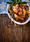 Roast chicken stuffed with thyme and physalis on a bed of sweet potato