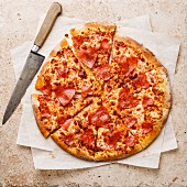 Pizza mit herzförmiger Peperoni-Salami auf Steinuntergrund