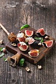 Sliced figs with ricotta, basil leaves, hazelnuts and honey