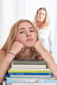 Girl leaning on elbows with text books