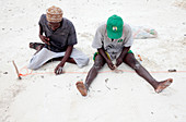Fishermen repairing a net
