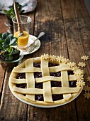 An unbaked pie with berries, cherries, rose water and a lattice top