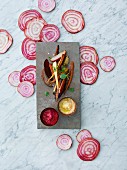 Baked root vegetables with red and yellow hummus