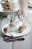 Stollen balls on wooden skewers being covered in rosemary and vanilla sugar