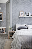 Bedroom in shades of gray with a wiped wall