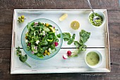 Vegan mixed garden salad on a wooden tray