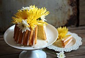 A yellow cake with flowers, one slice removed