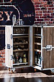 Bar in einer rollbaren aufklappbaren Holzkiste vor Backsteinwand