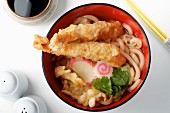A broth with wheat noodles, vegetables and prawn tempura (Asia)