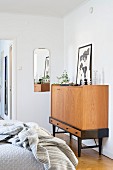 Candlesticks and picture leaning against wall op top of tall sideboard in bedroom