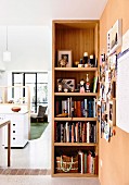 Open shelf with books and accessories and a view of an open living area