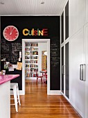 Black chalkboard paint on kitchen wall with passage into dining area