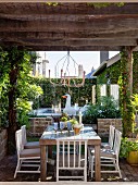 Terrassenplatz mit begrünter, rustikaler Pergola und Pool mit Schwimmtier im Hintergrund