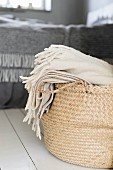 Cream woollen blanket in rattan shopping basket