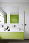 Modernes Badezimmer mit grünem Waschtisch und Fliesenspiegel